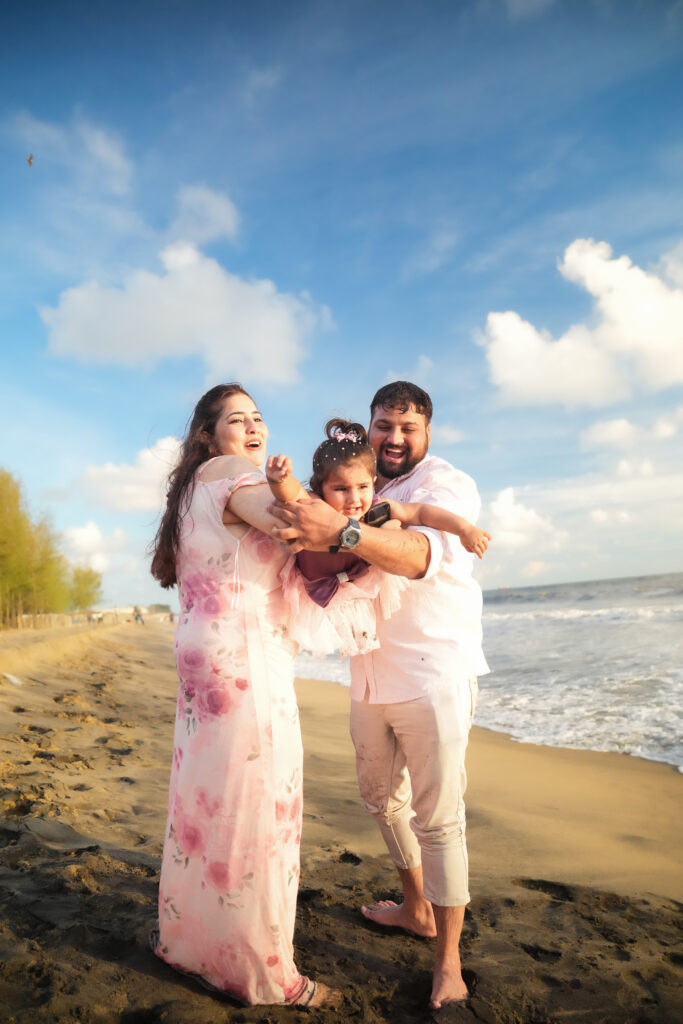 Happy family of three posing together during an outdoor photoshoot in Kochi.