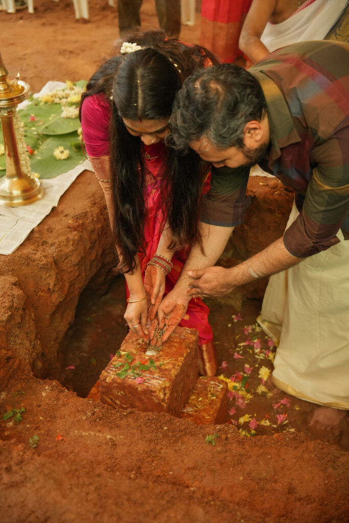 Traditional Kallidal ceremony photography in Kochi capturing the first stone laying ritual, family prayers, and sacred pooja for a new home.