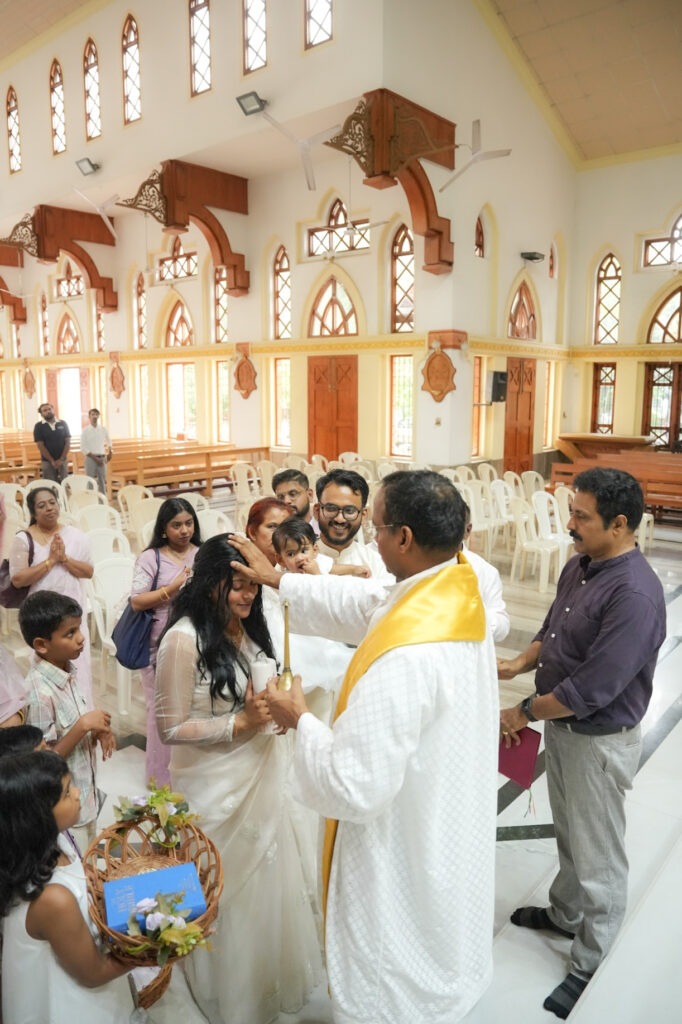 Candid baptism photography in Kochi capturing a baby’s baptism ceremony and family moments in Kerala